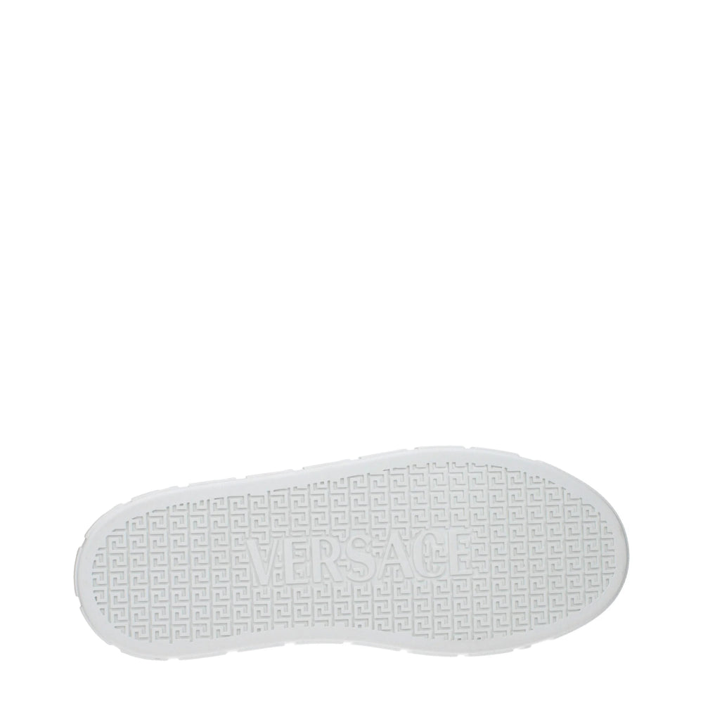 Vy ovanifrån av Versaces vita lädersneakers med låg skaft, som visar den vadderade innersulan och den eleganta mandelformade tån.