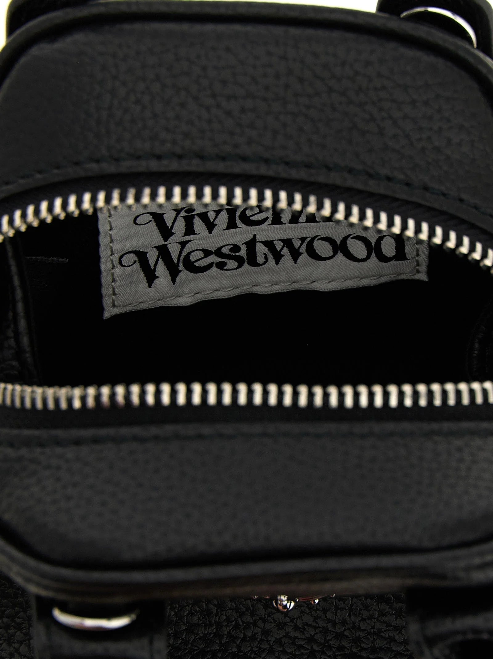 Detailaufnahme der Vivienne Westwood silberfarbenen Orb-Hardware auf dem strukturierten schwarzen Polyethylen-Material.