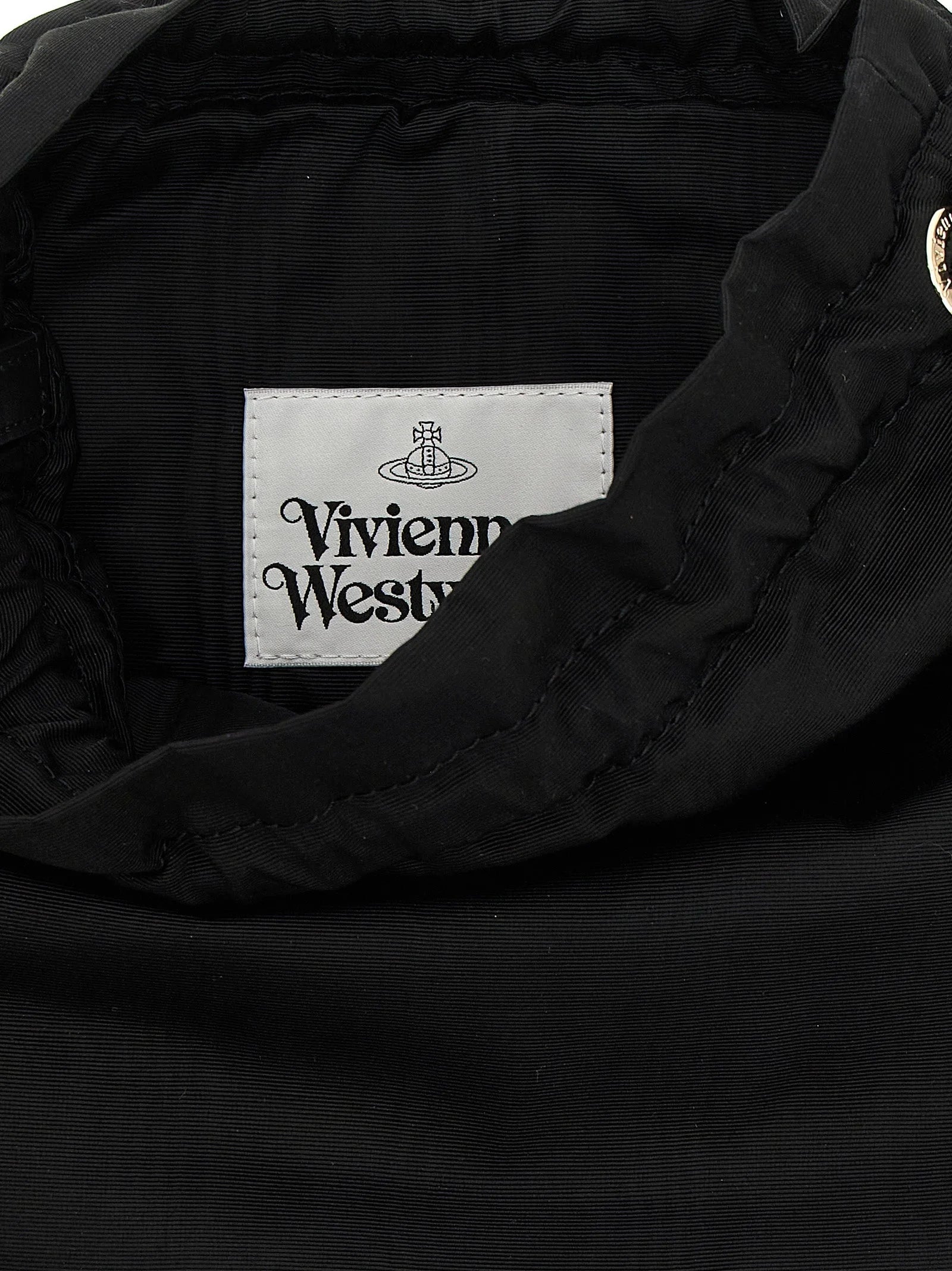 Detailaufnahme der Vivienne Westwood Orb-Beschläge und des komplizierten Webstuhls des schwarzen Viskose-Materials.