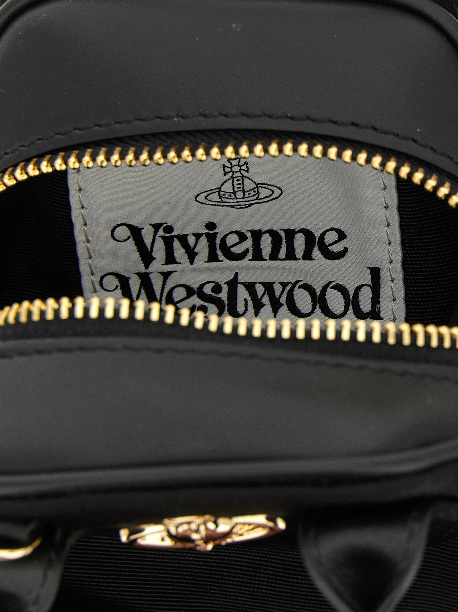 Närbild av Vivienne Westwoods handväska som visar den intricata texturen i svart viskos och silverbeslag.